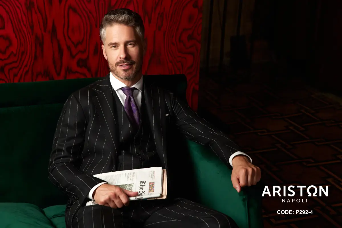 Black pinstripe three-piece suit with a white shirt and purple paisley tie—sharp, classic power tailoring