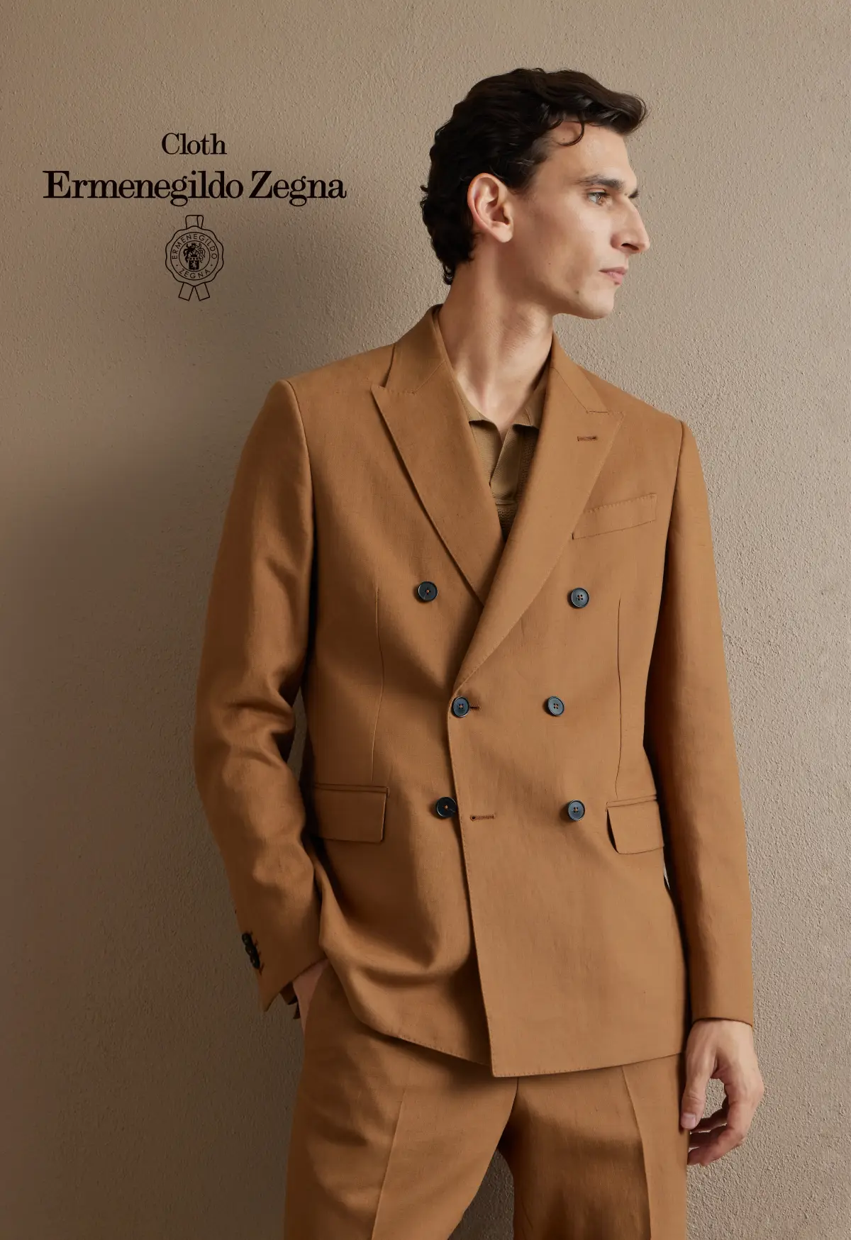 Camel double-breasted suit with notch lapels, styled tonally with a camel knit polo—minimal, modern summer tailoring