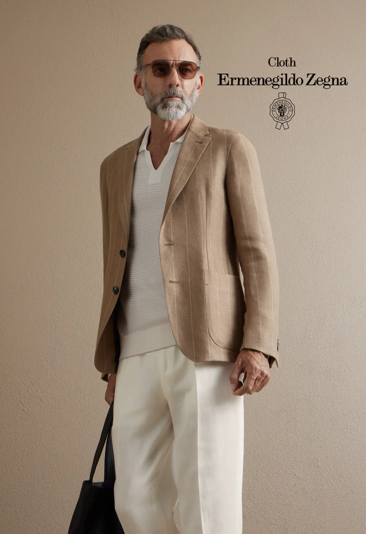 Caramel chalk-stripe blazer over an ivory open-placket knit and white trousers; sunglasses and a black tote give relaxed Riviera polish